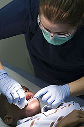 A patient gets his teeth examined at a Wingra Clinic health fair.