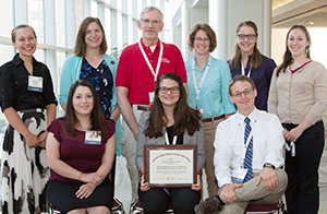 David Deci, MD (in red) and FMIG students with the AAFP Program of Excellence award.