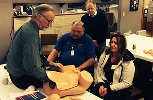 Ryan Brothers Ambulance Service medical director John Yost, MD, observes as Lou Sanner, MD, MSPH, teaches basic life support in obstetrics skills to paramedics there.