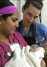 Sakina Sachak, MD, and Gretchen Adams, with a newborn baby they helped deliver.