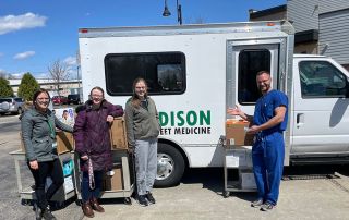 Volunteers standing in front of a truck, collecting donations.