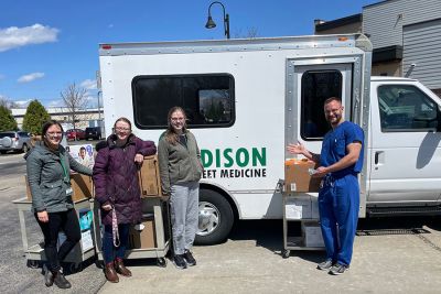 Volunteers standing in front of a truck, collecting donations.