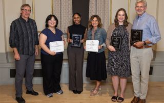 Group photo of six people with winners holding awards.