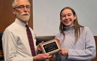 Tom Hartjes, MD handed an award by a student.