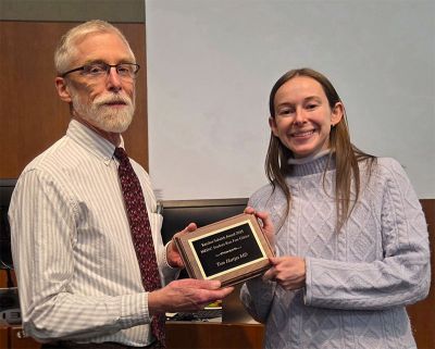 Tom Hartjes, MD handed an award by a student.