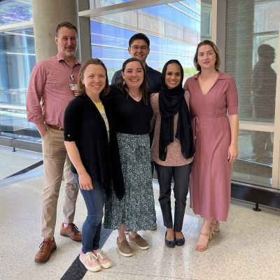 Six members of the PROTEA Team stand in a sunny hallway.