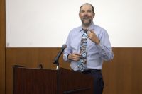 James Bigham, MD, MPH, presents from behind a podium.
