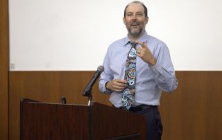 James Bigham, MD, MPH, presents from behind a podium.